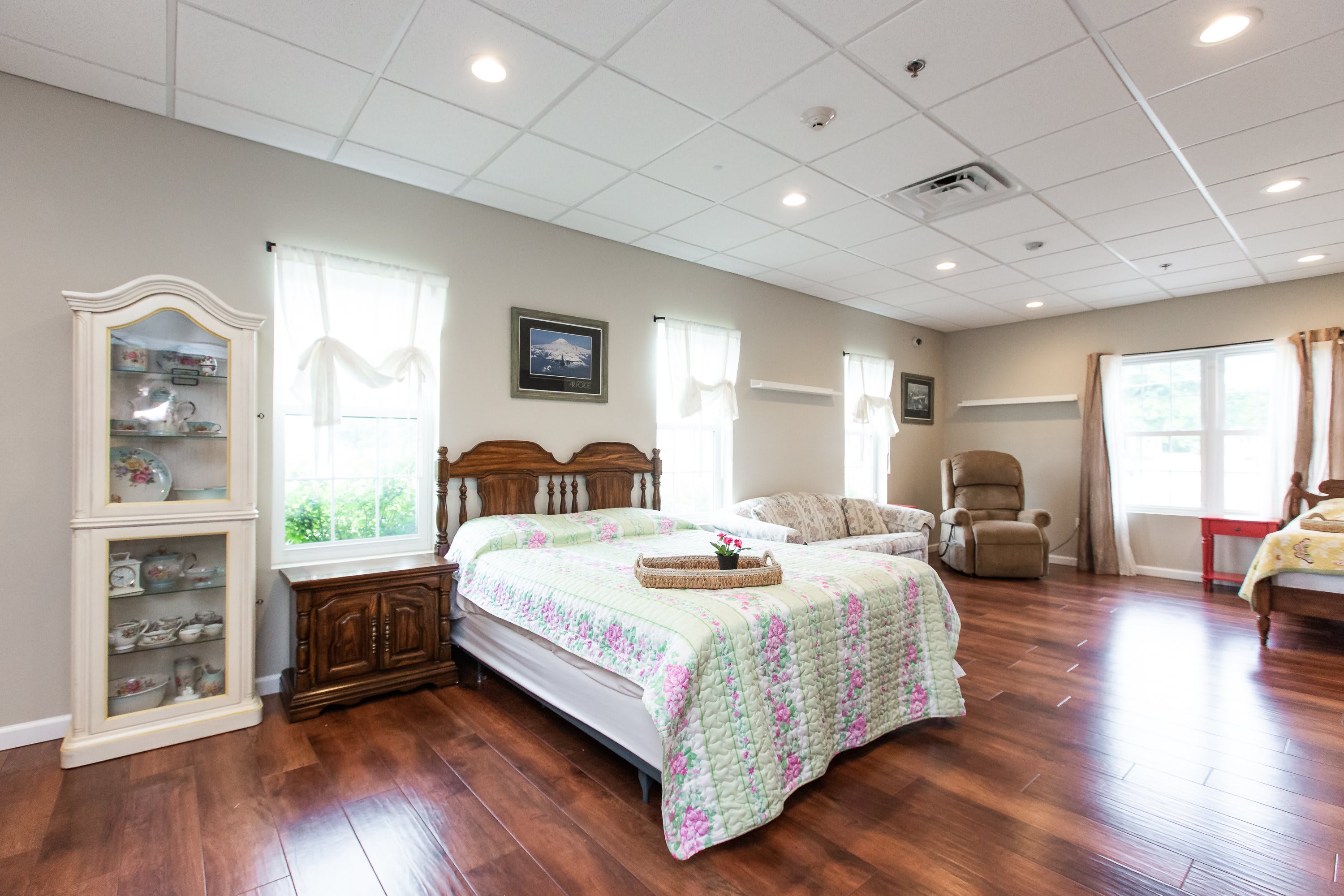 Bright semi-private bedroom with honey wood floors