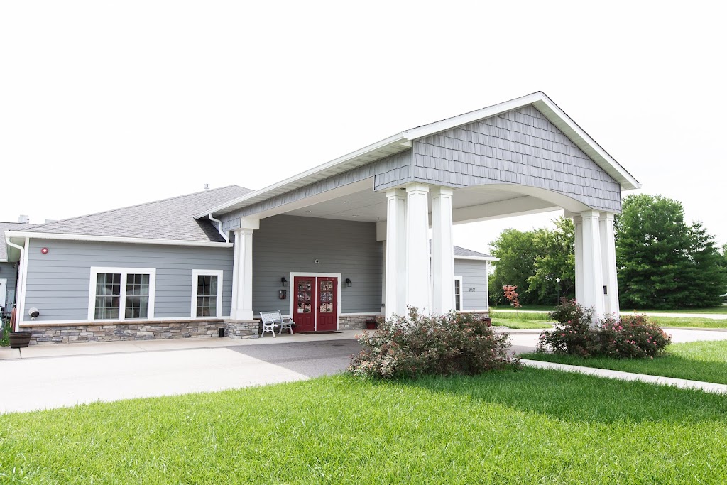 Front entrance of Joe’s Place Caring Cottage with covered porch and red doors in O’Fallon, Illinois