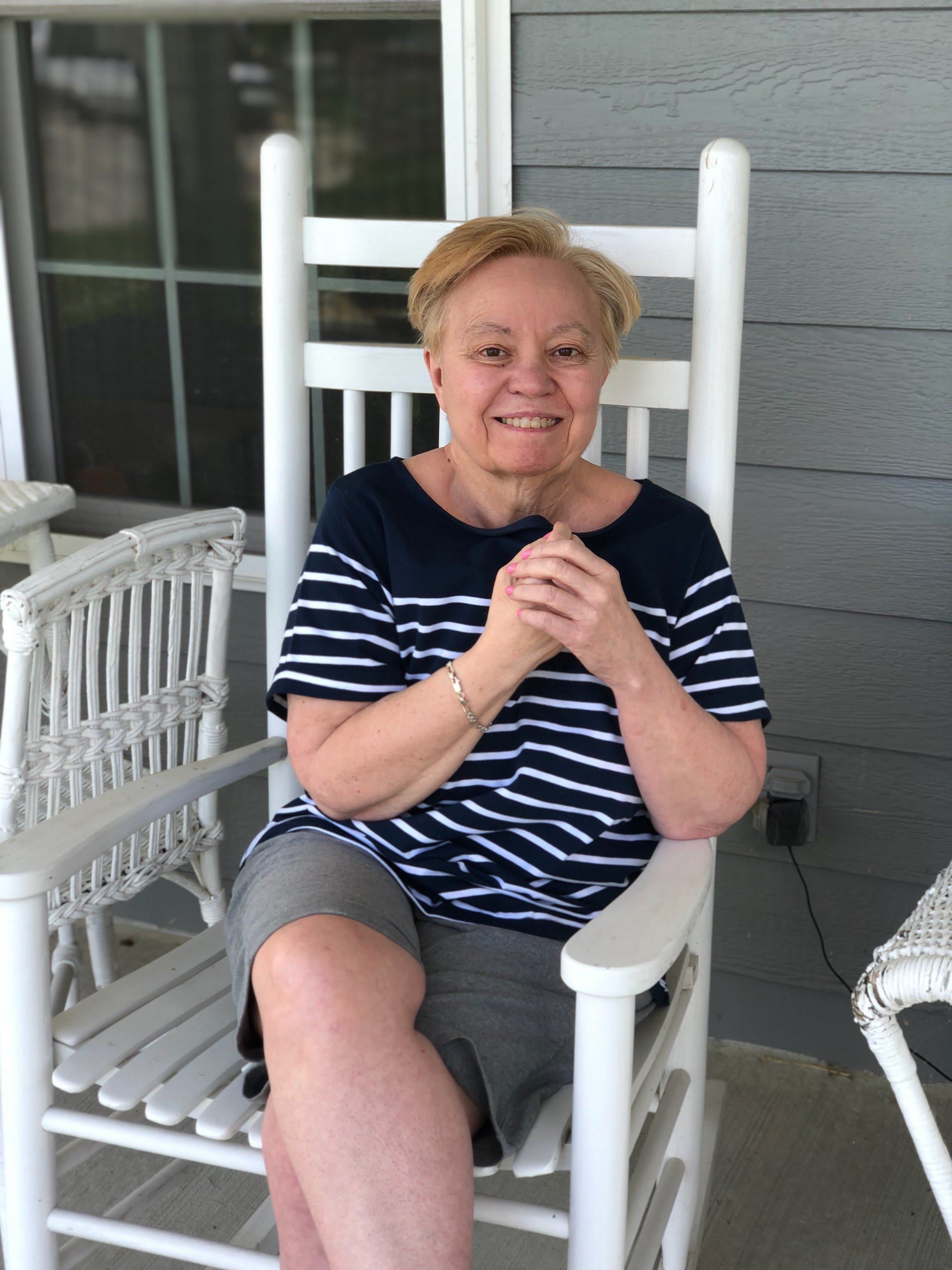 Resident smiling on the cottage porch