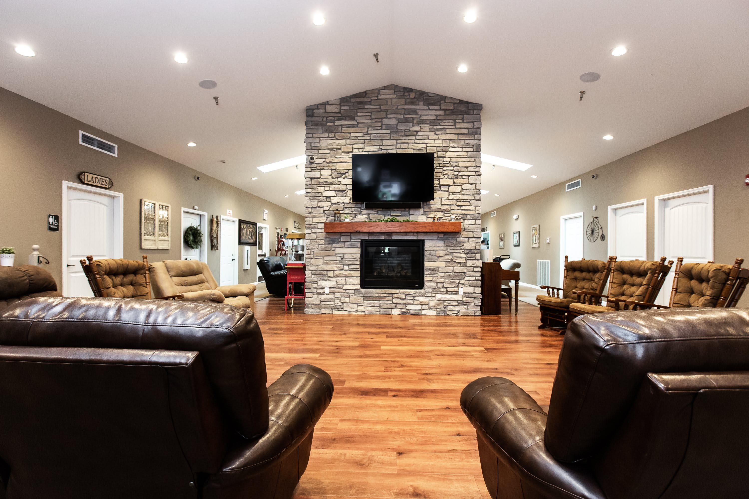Homelike common living room with stone fireplace and comfortable seating